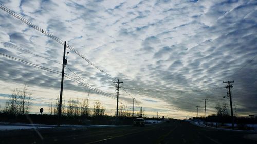 Road against cloudy sky at sunset