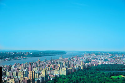 High angle view of city buildings against blue sky