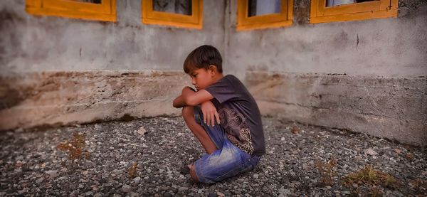 Boy sitting on wall