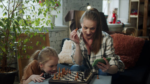 Mother playing chess with daughter