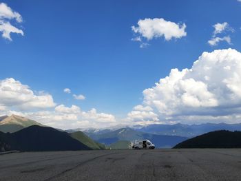 Road by mountains against blue sky