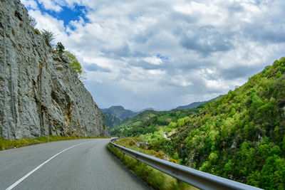 Surface level of road amidst mountains against sky