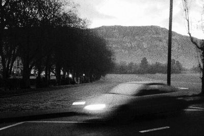 Empty road with trees in background