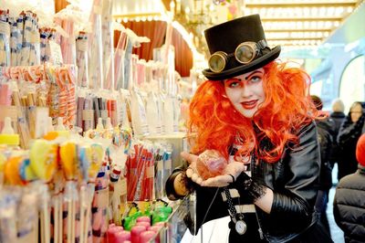 Portrait of young woman dressed up in steam punk standing at shop