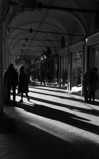 Rear view of people walking on road in city