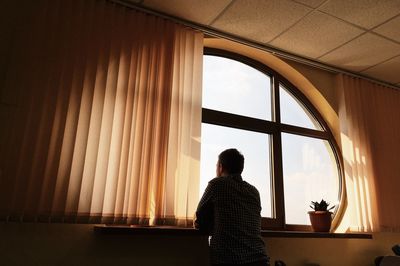 Man looking through window