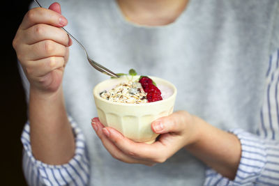 Midsection of woman holding food in bowl