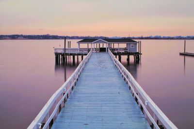 Pier over sea against sky during sunset