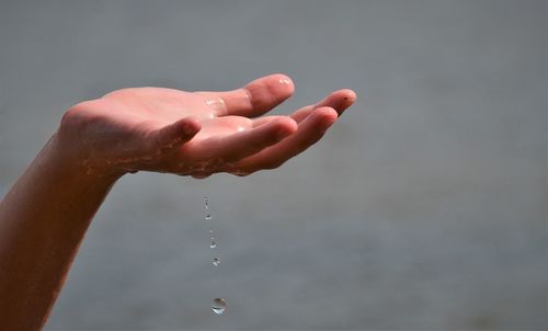 Close-up of cropped wet hand