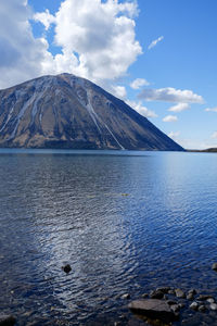 Scenic view of lake by mountain against sky