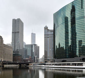 Big city reflections in glass windows and river in winter