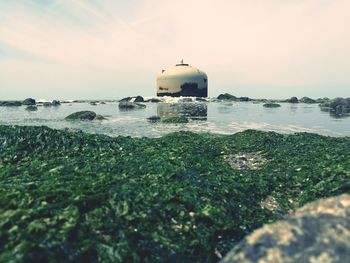 Built structure at sea shore against sky