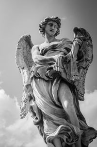 Low angle view of angel statue against sky