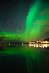 Scenic view of lake against aurora borealis at night