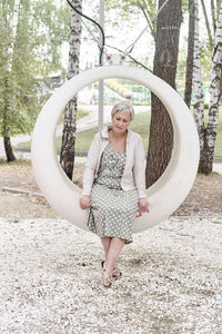 Portrait of a smiling young woman standing against trees