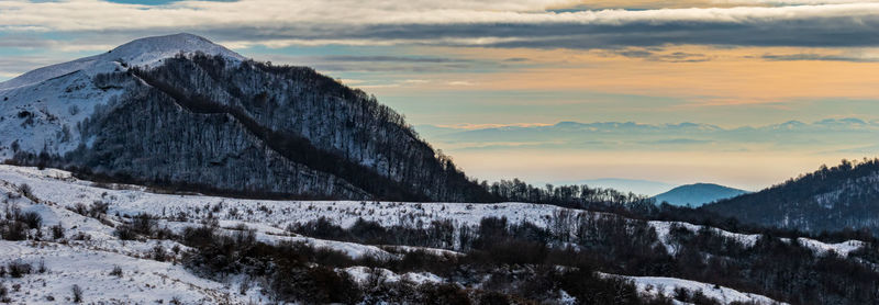 Scenic view of snowcapped mountains against sky during sunset