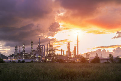 Panoramic view of factory against sky during sunset