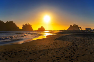 Scenic view of beach against sky during sunset