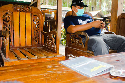 Full length of young man sitting on seat