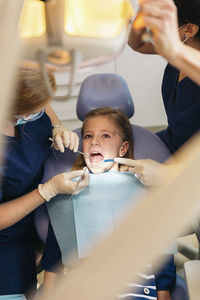 Female dentists examining girl at clinic