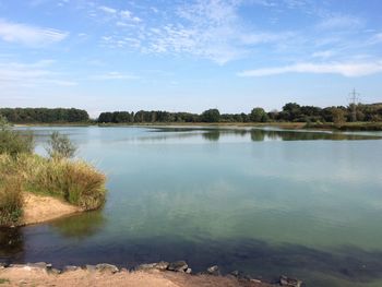 Scenic view of lake against cloudy sky