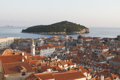 High angle view of townscape by sea against sky