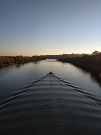 Scenic view of lake against clear sky during sunset