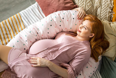 High angle view of woman sitting on bed at home