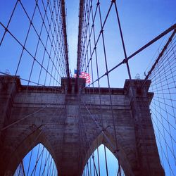 Low angle view of suspension bridge against sky