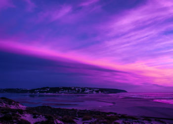 Scenic view of sea against dramatic sky at sunset