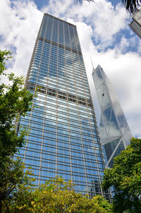 Low angle view of glass building against sky