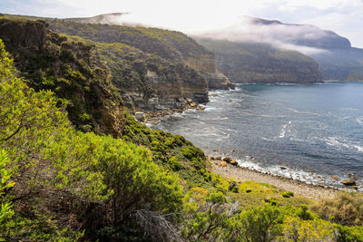 Scenic view of sea and mountains against sky