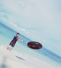 Young man on beach against sky