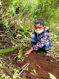 Portrait of cute boy lying on land