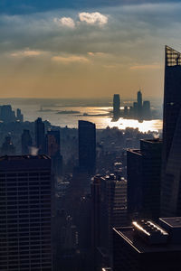 Buildings in city against sky during sunset