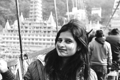 Portrait of smiling woman standing on bridge