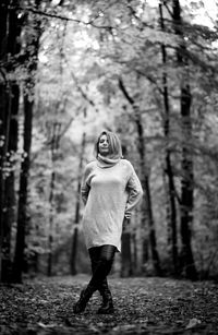 Full length portrait of woman standing in forest