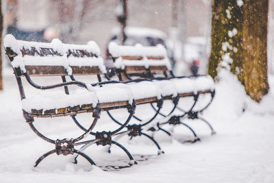 Snow covered benches in park during winter