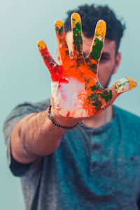 Close-up of hand holding orange leaf