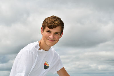 Portrait of young man standing against sky