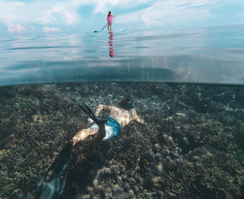 Young couple have a fun in ocean, underwater view