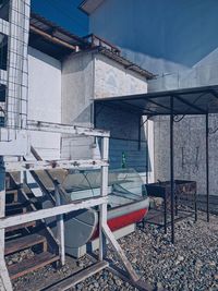 Empty chairs and tables against building