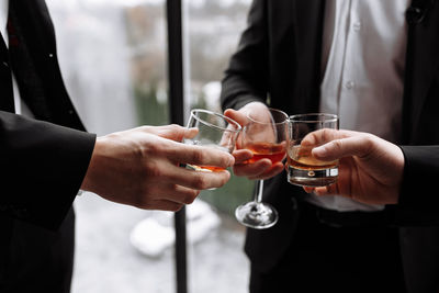 Midsection of man holding wine glass