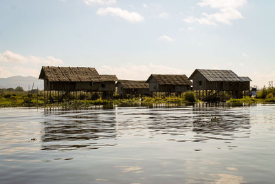 Houses by water against sky