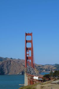Golden gate bridge over sea against blue sky