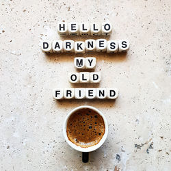 Directly above shot of coffee cup with text on stone table 