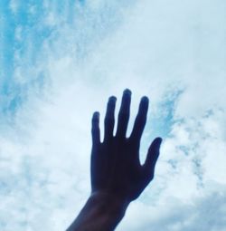 Low angle view of hand against sky