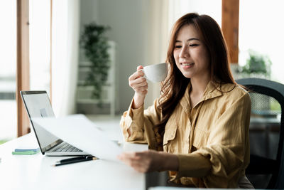 Young woman using laptop at office