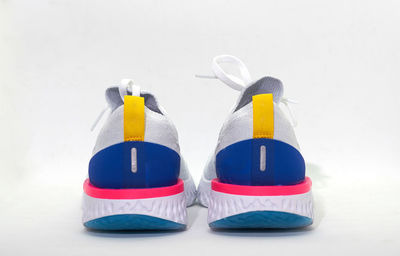 Close-up of multi colored shoes over white background