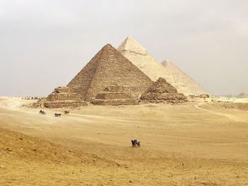 Scenic view of desert against sky pyramids 